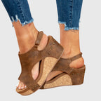 Brown cushioned wedge sandals with crisscross straps and stud accents on the upper.