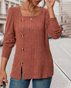 Rust orange knit top with square neckline, gold button front, and side slit hem