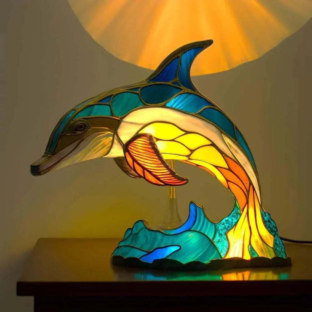 Dolphin-shaped stained-glass table lamp with glowing warm light from the figure