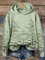 Green floral-embroidered hoodie with scalloped lace hem.