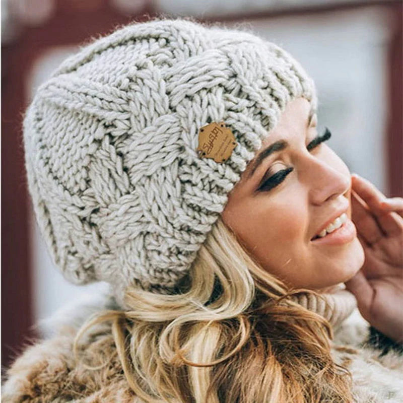Cream chunky knit beanie hat with small brown brand patch