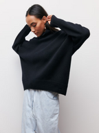 Dark knitted turtleneck sweater with long sleeves and ribbed neckline