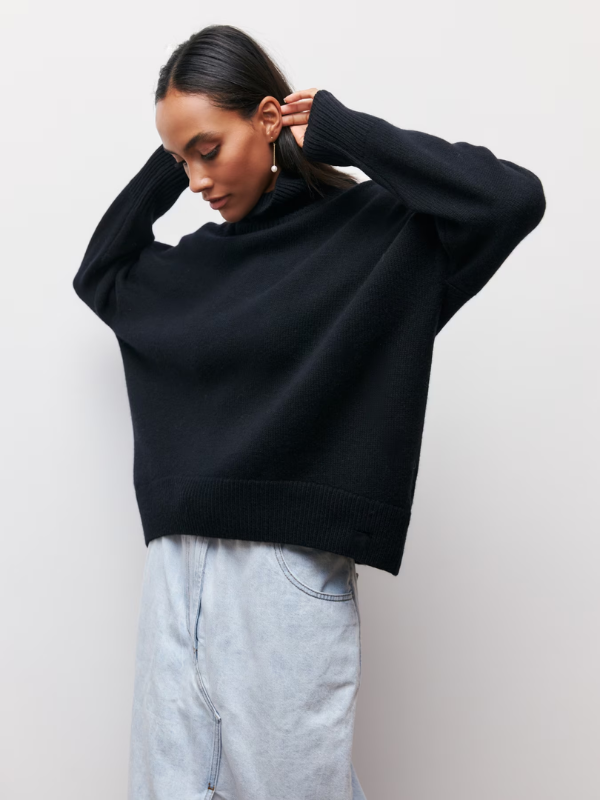 Dark knitted turtleneck sweater with long sleeves and ribbed neckline