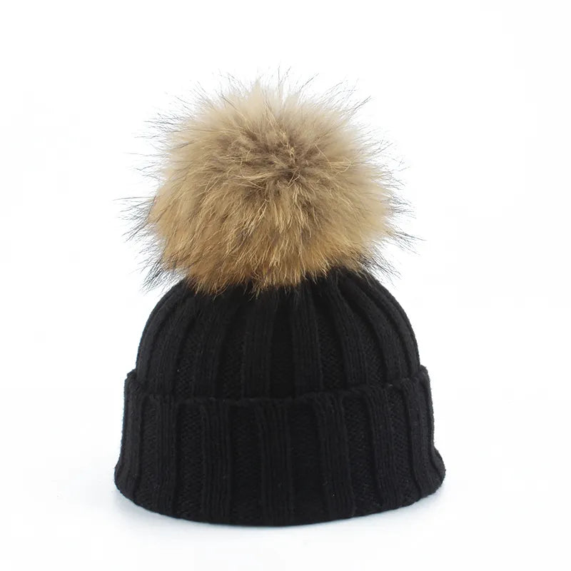 Knit beanie hat with tan pom-pom, ribbed texture, black color
