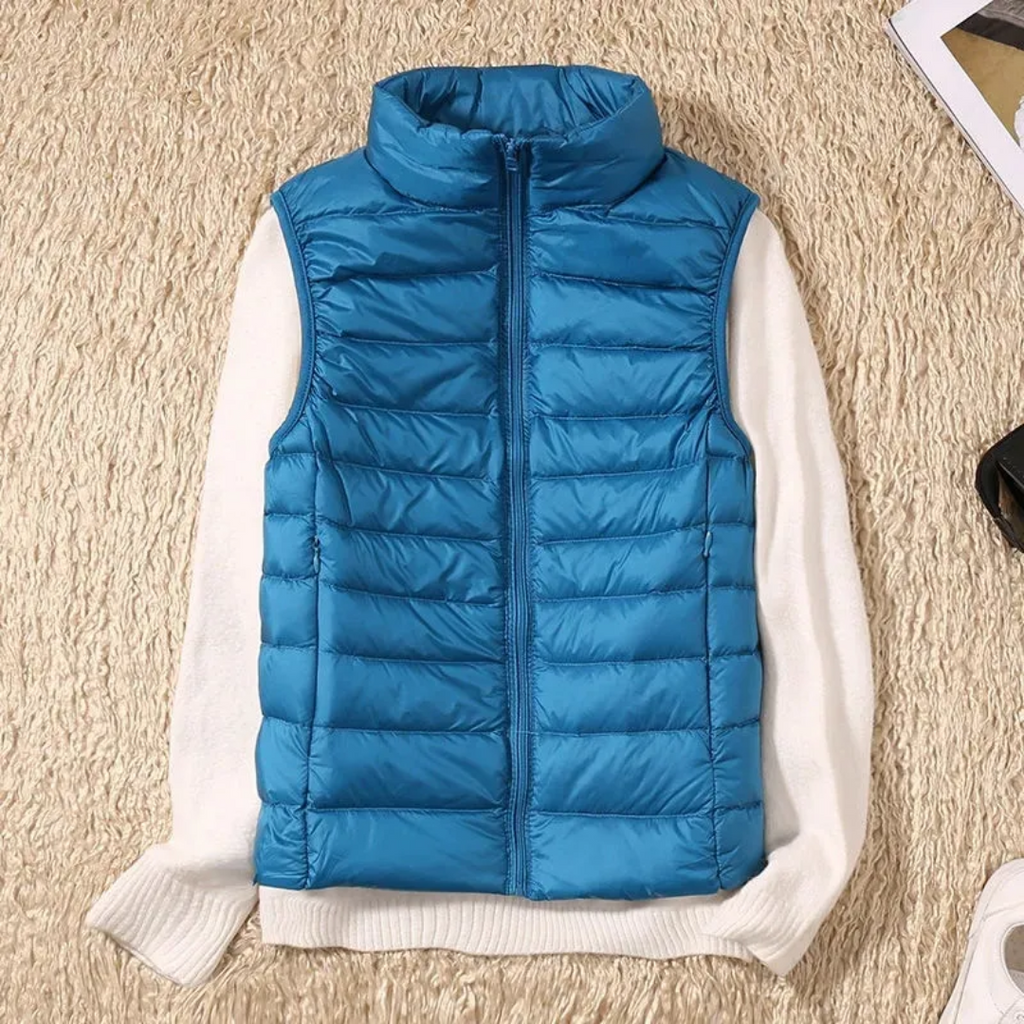 Blue quilted bodywarmer vest with full-zip and stand collar over white sleeves