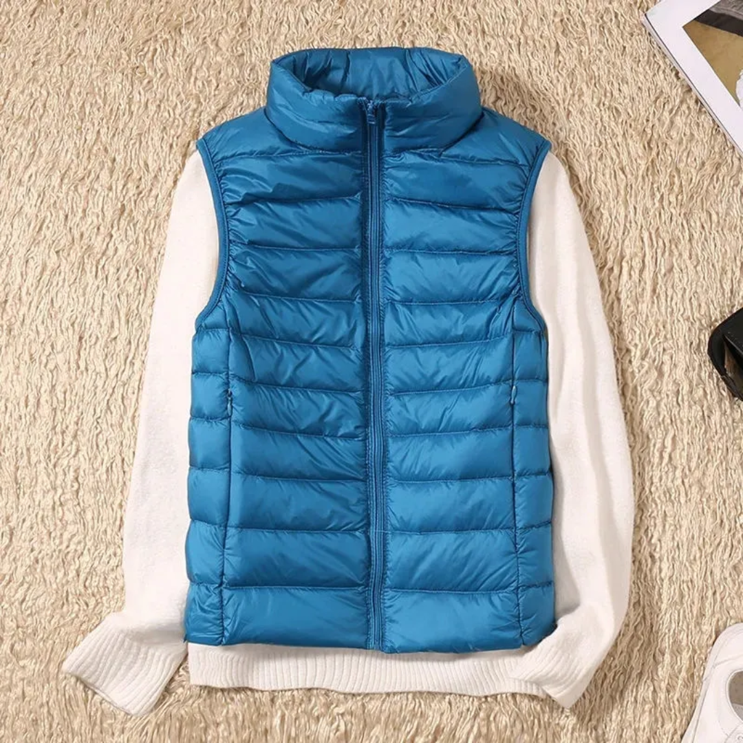 Blue quilted bodywarmer vest with full-zip and stand collar over white sleeves