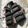 Black puffer bodywarmer with beige ribbed sleeves, zip front and stand collar