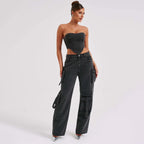 Black high-waist cargo jeans with relaxed fit and flap utility pockets, tie accents.