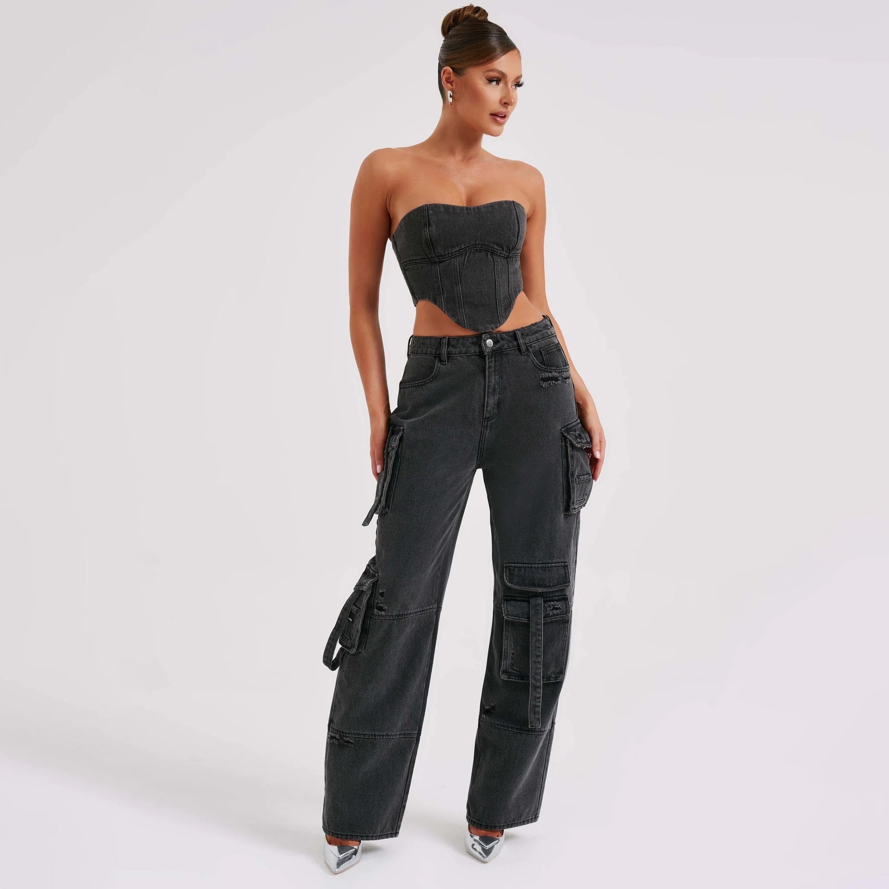 Black high-waist cargo jeans with relaxed fit and flap utility pockets, tie accents.