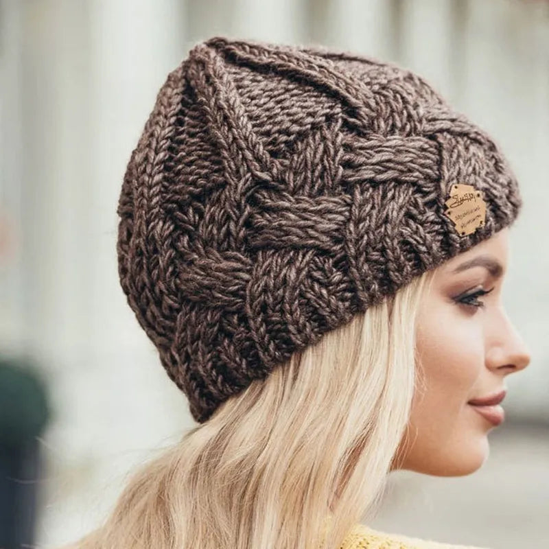Brown cable-knit beanie hat with small brown brand patch