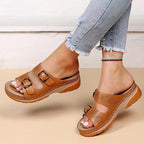 Tan double-buckle slip-on sandals with perforated straps and cushioned platform sole