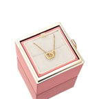 Pink jewelry gift box with gold heart pendant necklace on white display pillow