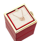 Pink jewelry gift box with rose-gold heart pendant necklace on white display pillow