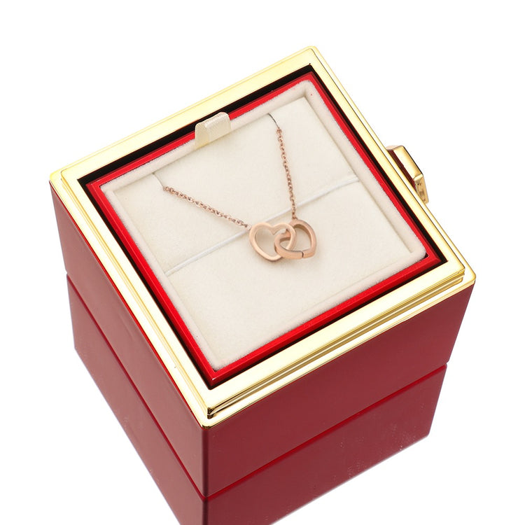 Pink jewelry gift box with rose-gold heart pendant necklace on white display pillow