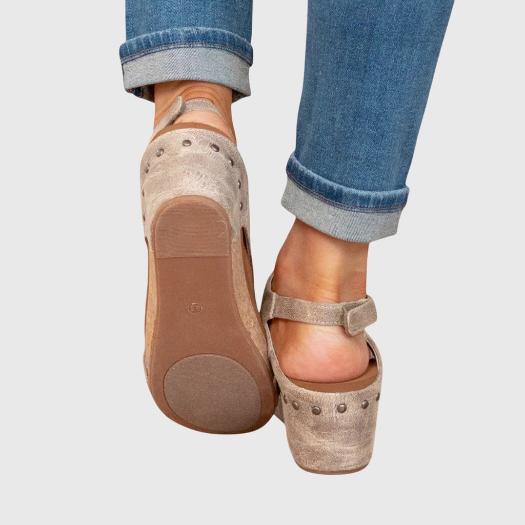 Beige wedge sandals showing heel and adjustable ankle strap with buckle detail.
