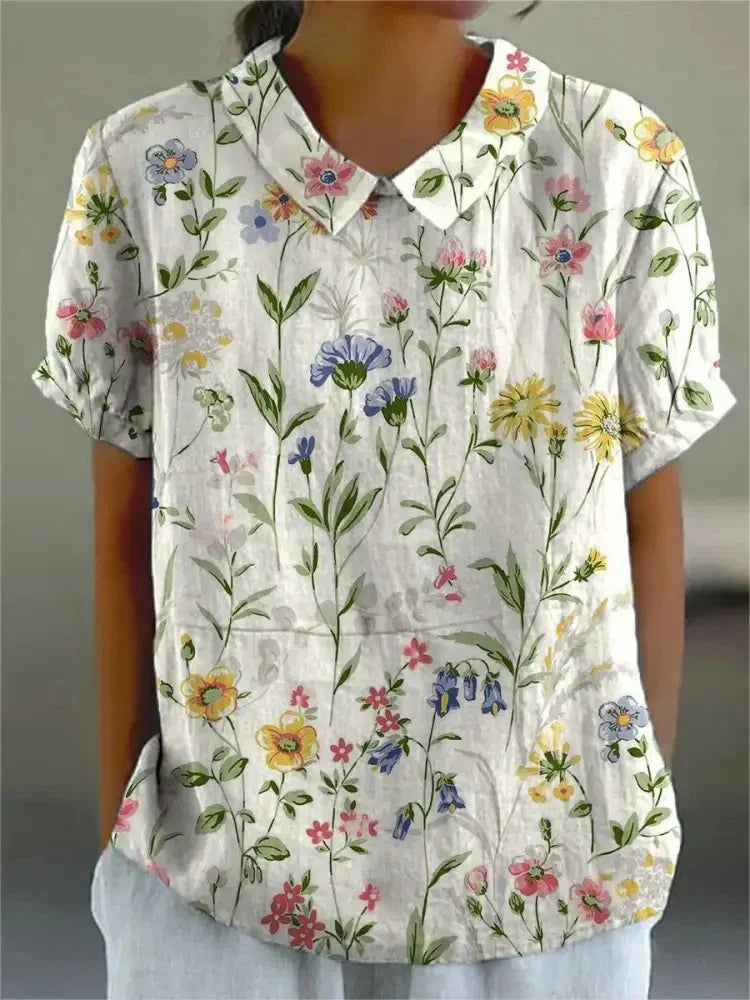 Floral print short-sleeve blouse in white with buttoned V-neck collar detail