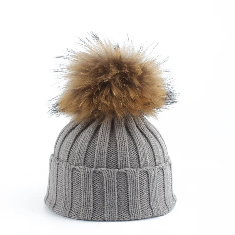 Knit beanie hat with tan pom-pom, ribbed texture, gray color