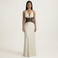 Cream halter maxi dress with deep V front and black lace waist panel, sleeveless.