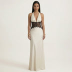 Cream halter maxi dress with deep V front and black lace waist panel, sleeveless.