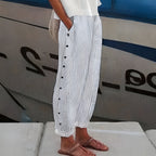 Women’s white and dark striped trousers with vertical button detail along the front