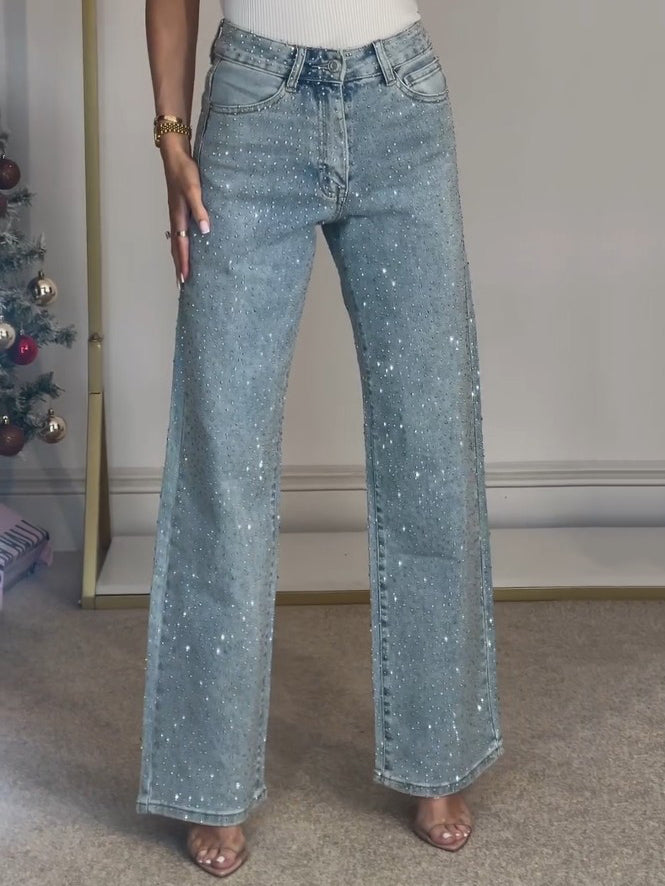 Light blue high-waist wide-leg denim jeans with sparkling details and classic front closure.