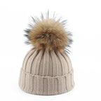 Knit beanie hat with tan pom-pom, ribbed texture, light taupe color