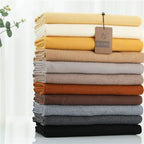 Neutral-toned cashmere scarf stack in folded layers with tags