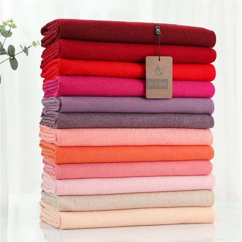 Pink and red cashmere scarf stack in folded layers with tags