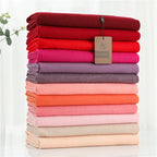Pink and red cashmere scarf stack in folded layers with tags