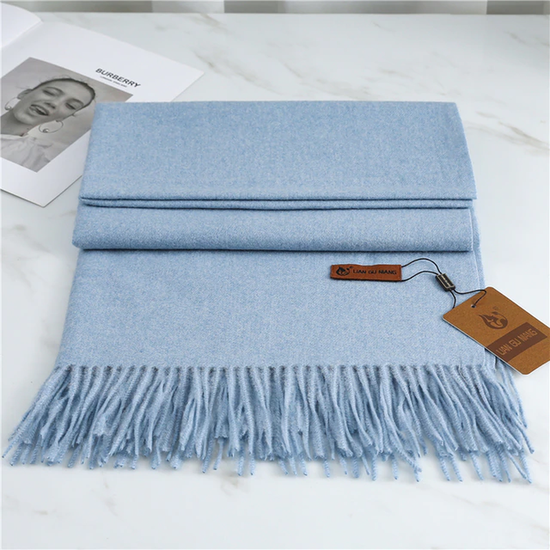 Blue cashmere scarf with fringed ends, folded and stacked