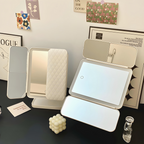 Triple-light LED makeup mirror with open screens and quilted back cover on stand
