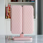 Pink LED makeup mirror with quilted double cover folded shut on pedestal base