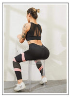 Women's high-waisted yoga leggings, back view, black with pink stripes and mesh calf panels