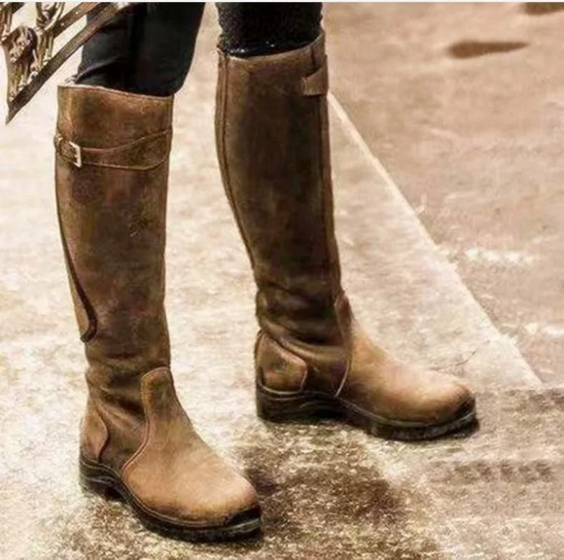 Brown knee-high waterproof boots with buckle strap and rugged grippy sole