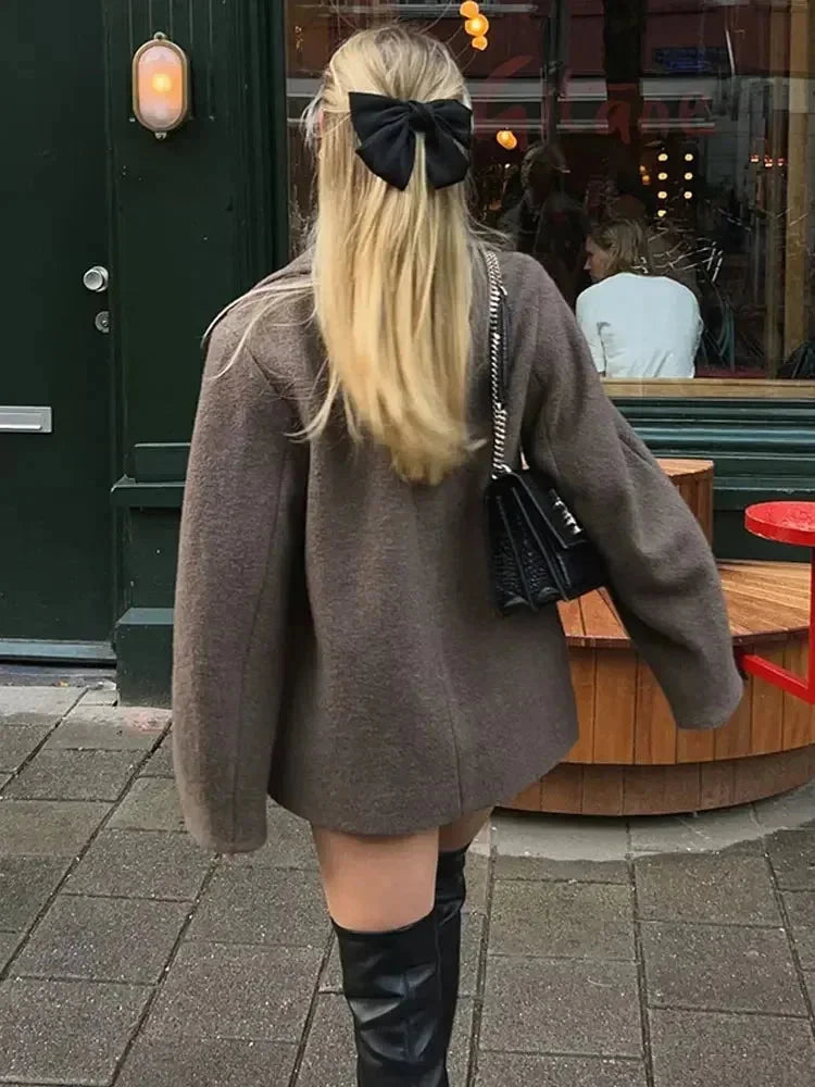 Back view of women’s oversized brown coat with long sleeves and button closure