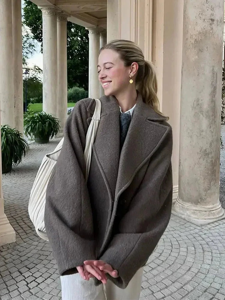 Women’s oversized brown coat with front buttons and wide lapels, side view