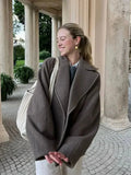 Women’s oversized brown coat with front buttons and wide lapels, side view
