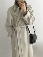 Long women's coat with waist belt and notched collar, light gray, front view