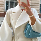 Women’s long white coat with wide collar and notched lapels, front button detail