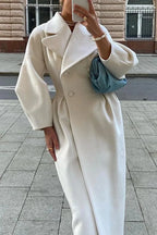 Women’s long white coat with wide collar, structured shoulders, buttoned front