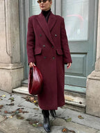 Burgundy long double-breasted coat with notched lapels and flap pockets