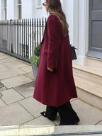 Burgundy long double-breasted coat with notched lapels and side button detail