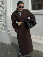 Long women's dark brown coat with notched lapels and voluminous sleeves