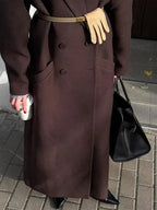 Long women's dark brown coat with gold-buckle belt and button details