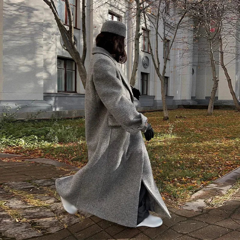 Long hooded dark gray pinstripe coat with draped silhouette and side pockets