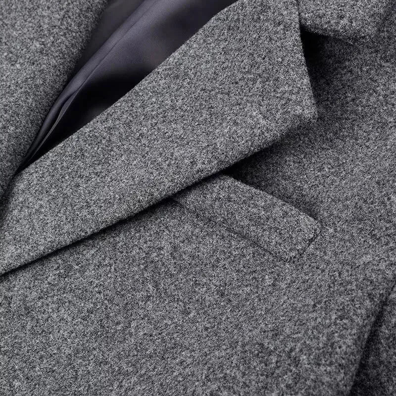Close-up of dark gray textured wool-like coat fabric with diagonal seam lines