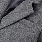 Close-up of dark gray textured wool-like coat fabric with diagonal seam lines