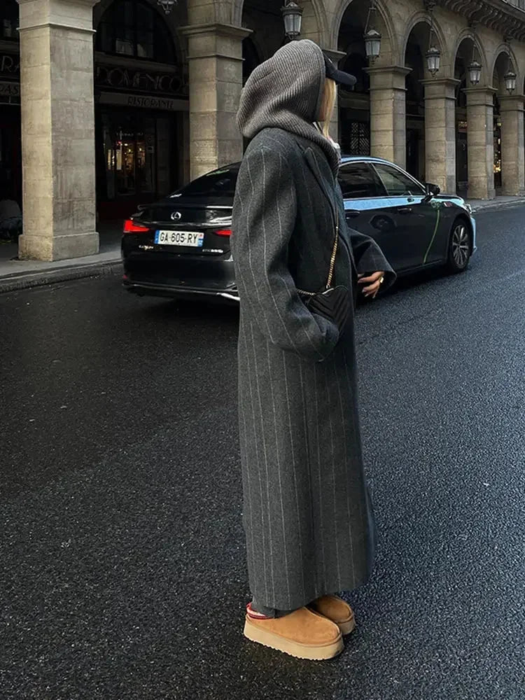 Long hooded dark gray coat with vertical pinstripes, front buttons, side pockets