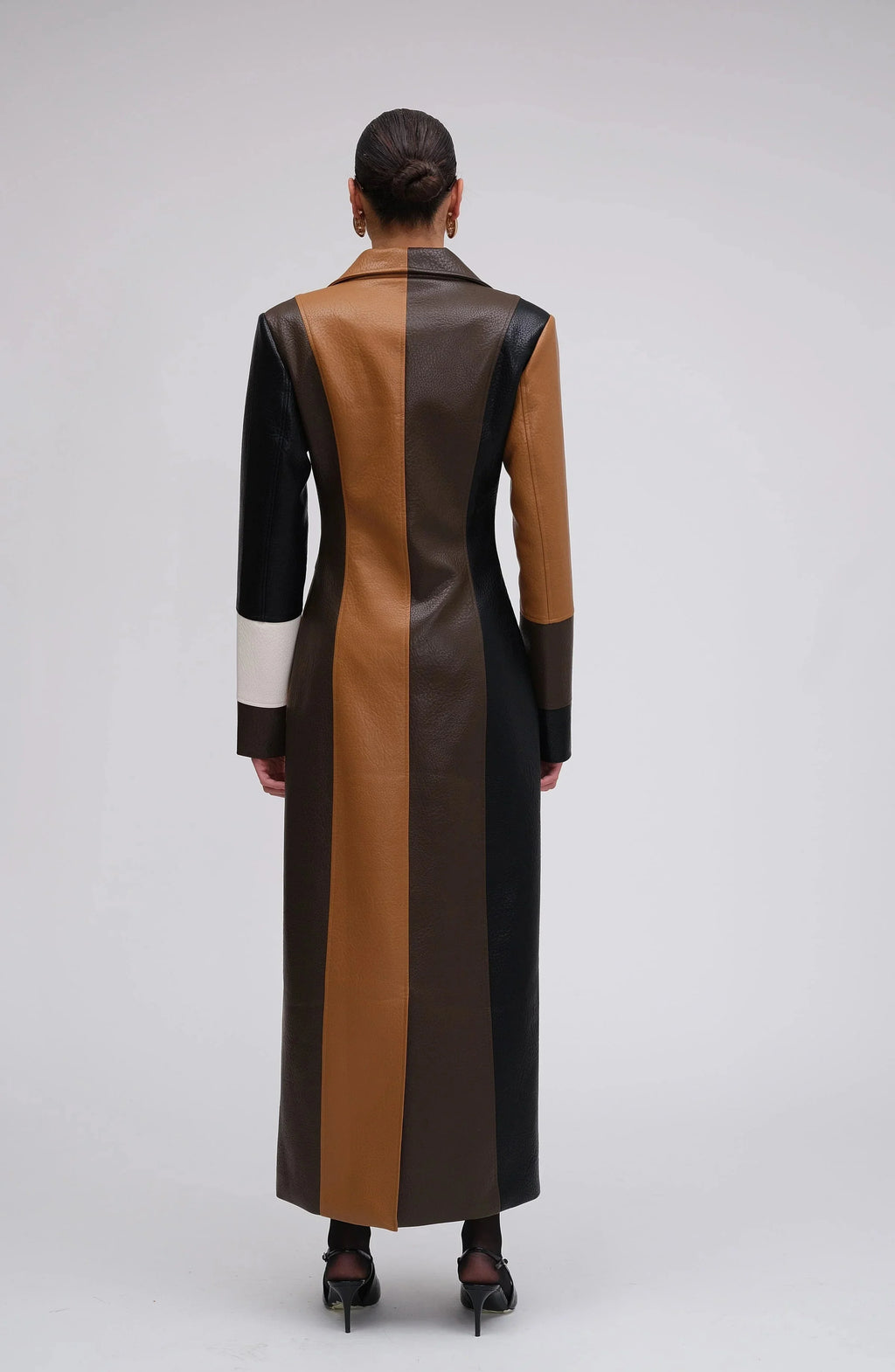 Long patchwork coat in black, brown, and white with vertical color blocks.