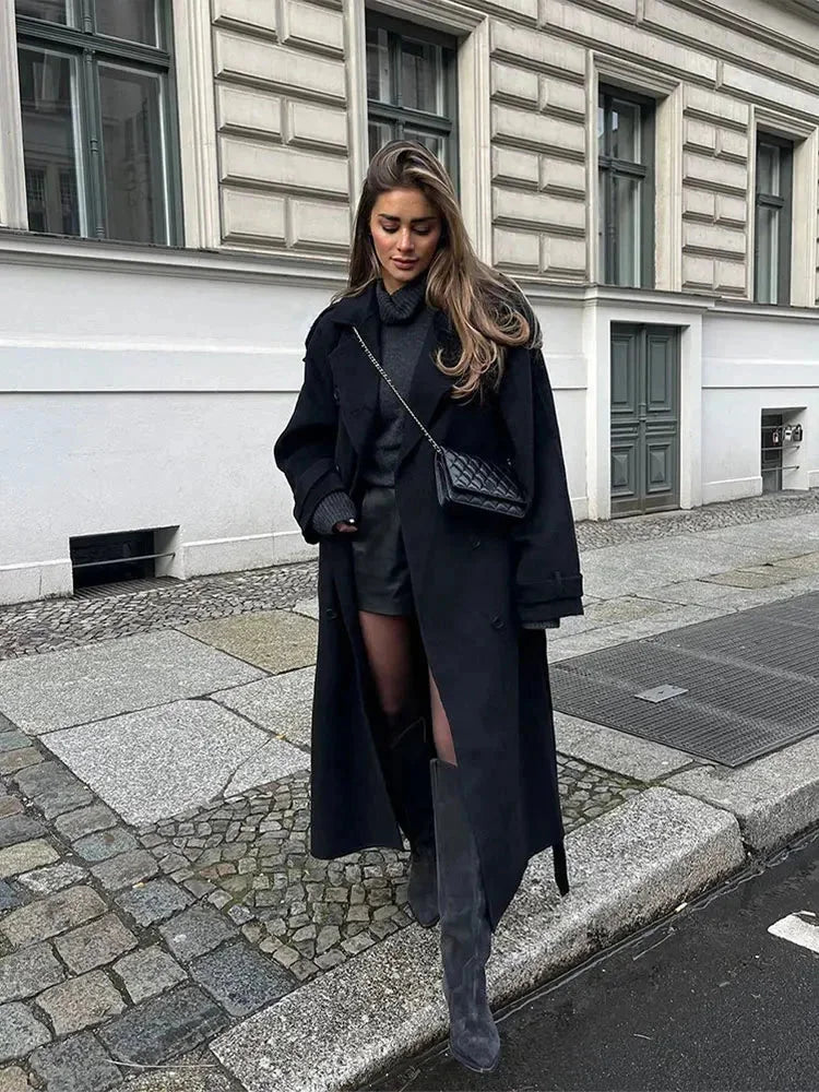 Women's black long belted coat with wide lapels and buttoned front